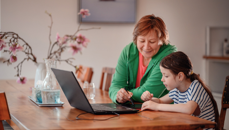 Un parent aide sa fille à faire ses devoirs sur un ordinateur portable Signpost avec Academic Software